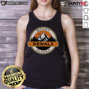 Model wearing a Good Mount Denali Alaska tank top against a scenic mountain backdrop, showcasing outdoor adventure style.