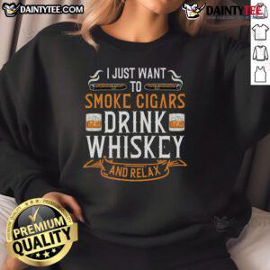 Man in a cozy sweatshirt enjoying a nice Cuban cigar and whiskey, perfect for relaxation moments.