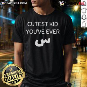 Alt Text: Cute kid wearing a Nicest Cutest Kid You've Ever Seen T-shirt, smiling joyfully in a sunny outdoor setting.