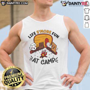 Person wearing a 'Nice Life's More Fun at Camp' tank top, roasting marshmallows by a campfire during a camping trip.