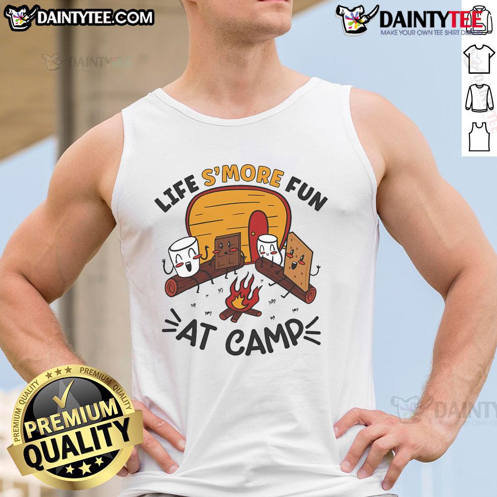 Person wearing a 'Nice Life's More Fun at Camp' tank top, roasting marshmallows by a campfire during a camping trip.