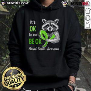 Funny raccoon graphic on a hoodie with the phrase It's Okay To Not Be Okay promoting mental health awareness.