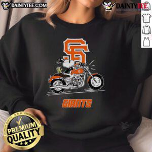Good Snoopy and Woodstock driving a motorbike, wearing San Francisco Giants sweatshirt, in a playful cartoon scene.