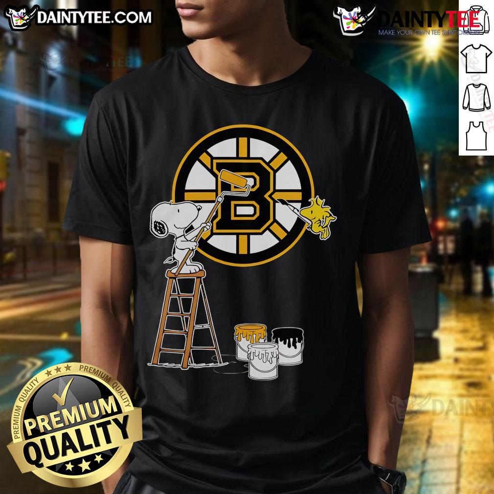 Snoopy and Woodstock painting Boston Bruins logo on a t-shirt, showcasing a fun and vibrant sports design.