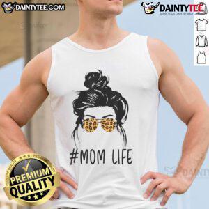 Classy mom in leopard pattern shades and a cool messy bun, wearing a stylish tank top, embodies awesome mom life.