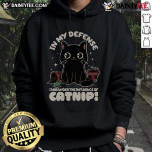 Funny cat in a cozy hoodie, captioned 'In My Defense, I Was Under The Influence of Catnip,' showcasing playful feline humor.