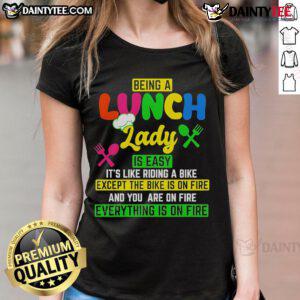 Funny ladies' tee featuring 'Being a lunch lady is easy, like riding a bike, except the bike is on fire' design.