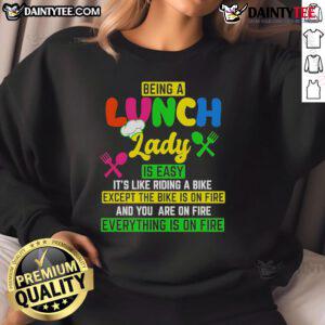 Cozy sweatshirt reading 'Being a Lunch Lady is Easy It's Like Riding a Bike Except the Bike is on Fire' for food service workers.