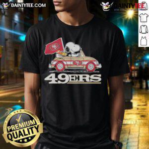 Alt Text: Official San Francisco 49ers X Snoopy T-Shirt featuring Woodstock driving a car, perfect for fans and collectors.