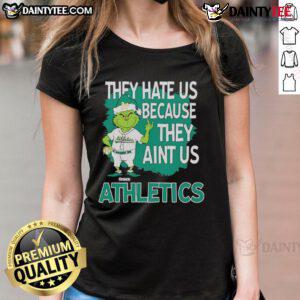 Alt Text: Awesome Athletics Grinch Christmas tee for ladies featuring 'They Hate Us Ain't Us' design in festive colors.