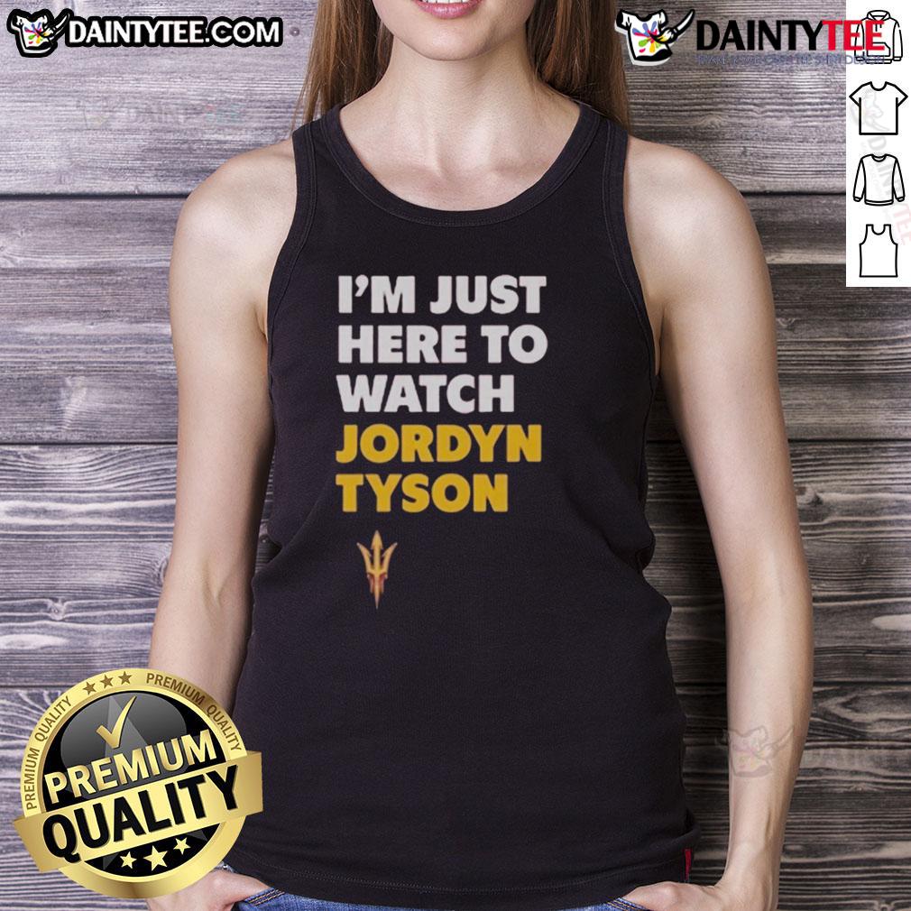 Alt Text: Jordyn Tyson wearing an 'I'm Just Here to Watch' tank top, showcasing a casual and stylish summer look.