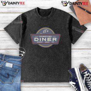 Funny AI character in a downtown diner enjoying breakfast burgers and fries, wearing a quirky washed T-shirt.
