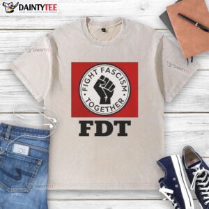 Alt Text: Good Fight Fascism Together logo on a washed t-shirt, promoting unity and activism against fascism.