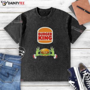 Good Grinch hands holding a Merry Christmas Burger King washed t-shirt, perfect for festive holiday cheer and style.