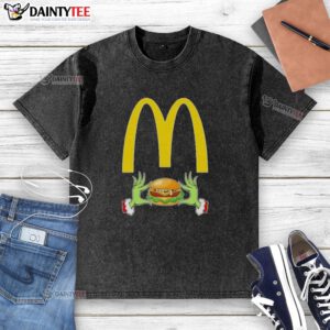 Good Grinch hands holding a McDonald's meal, wearing a Merry Christmas washed t-shirt, festive holiday spirit.
