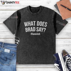 Alt Text: Hot What Does Brad Say Fanovich washed t-shirt displayed on a wooden background, showcasing its soft fabric and design.