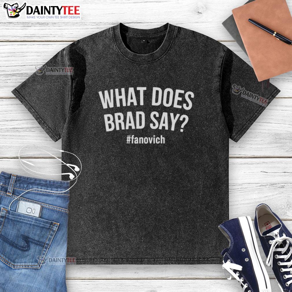 Alt Text: Hot What Does Brad Say Fanovich washed t-shirt displayed on a wooden background, showcasing its soft fabric and design.