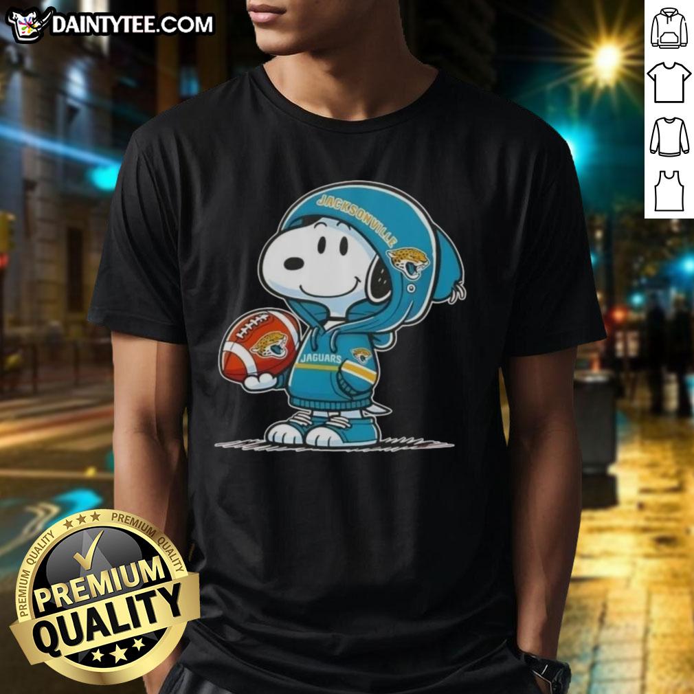 Alt Text: Happy Peanuts Snoopy in a hoodie, smiling at fans in a Jacksonville Jaguars T-shirt, perfect for NFL enthusiasts.