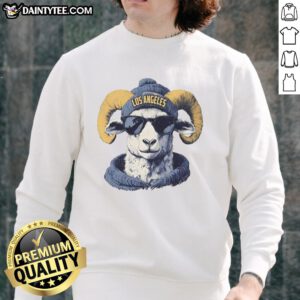 Awesome Los Angeles Rams mascot in a beanie and sunglasses, wearing a stylish sweatshirt at a game day event.