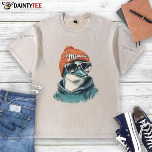Miami Dolphins mascot in a beanie and sunglasses, showcasing team spirit in a washed t-shirt at a game.