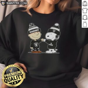 Cute Peanuts Charlie Brown and Snoopy fist bump in Las Vegas Raiders football sweatshirt, perfect for fans.