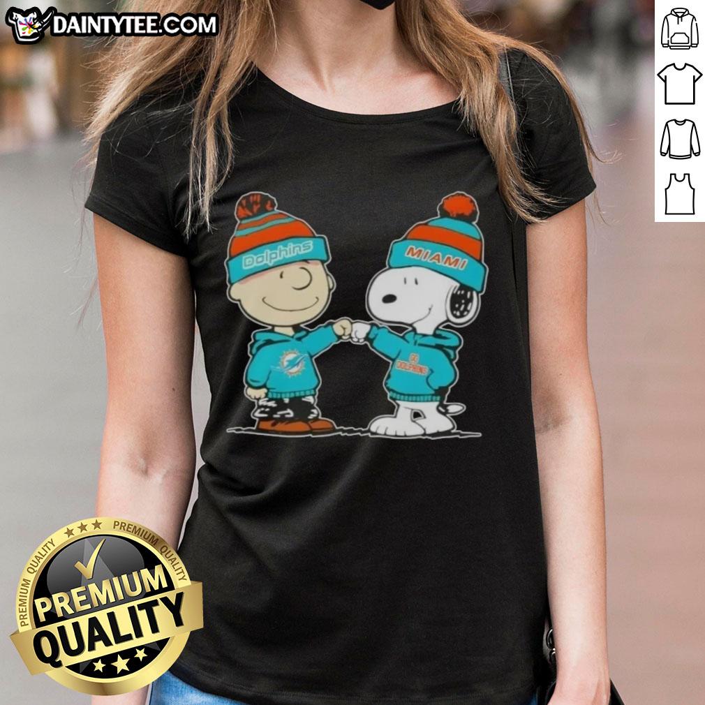Charlie Brown and Snoopy fist bump in Miami Dolphins gear on a cute ladies tee, perfect for football fans.