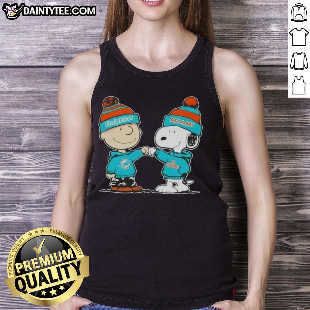 Adorable Charlie Brown and Snoopy fist bump on a Miami Dolphins football tank top, perfect for Peanuts fans.