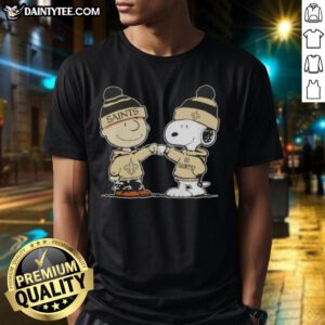 Charlie Brown and Snoopy fist bump on New Orleans Saints football T-shirt, perfect for fans of Peanuts and NFL.