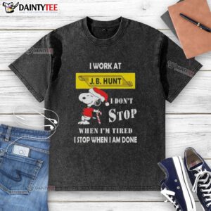 Funny Snoopy Christmas t-shirt featuring 'I work at J.B. Hunt, I don't stop when I'm tired, I stop when I'm done' slogan.