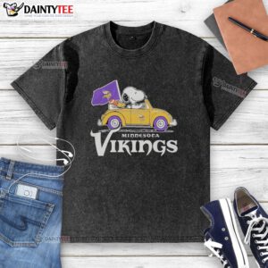 Alt Text: Good Snoopy and Woodstock riding a Minnesota Vikings football car logo on a washed t-shirt, perfect for fans.