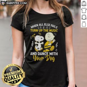 Alt Text: Snoopy and Charlie Brown dancing with a dog, showcasing the 'When All Else Fails, Turn Up the Music' tee design.