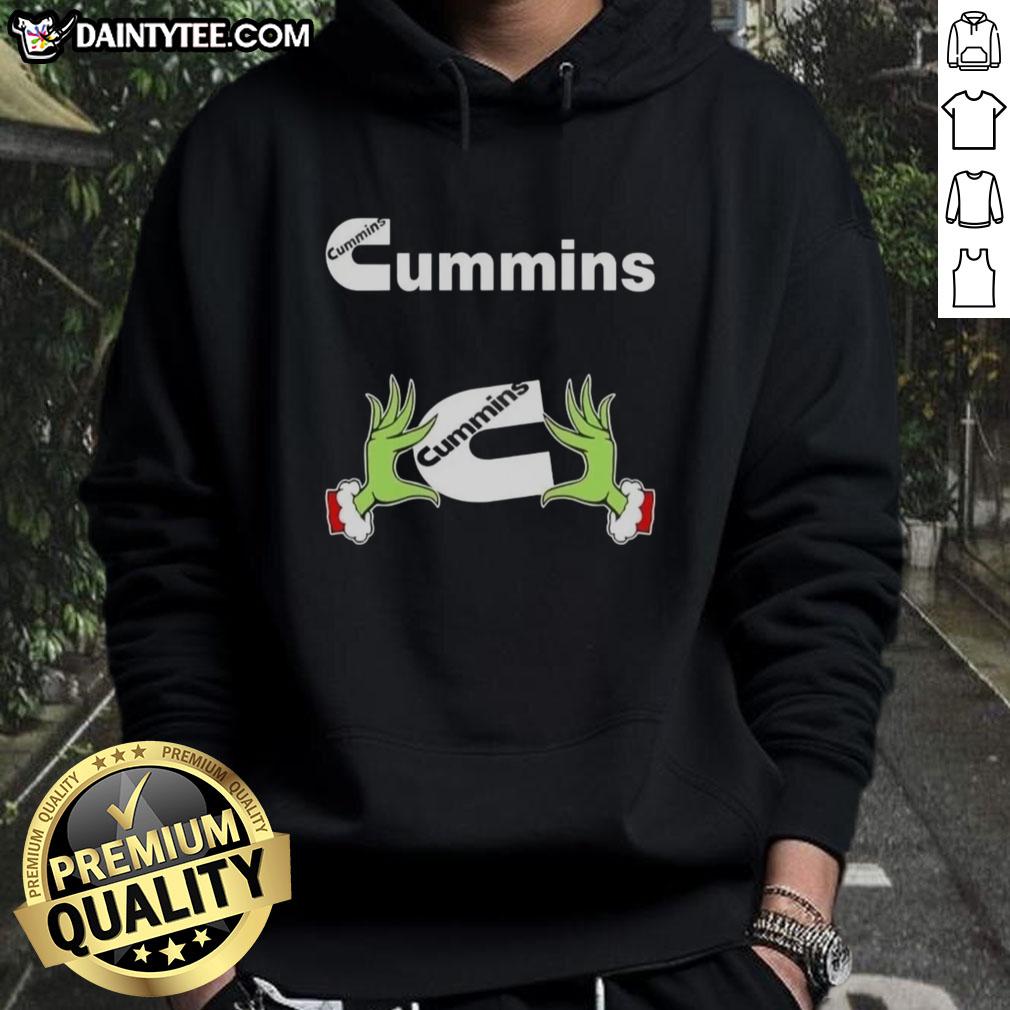 Premium Grinch hands holding a Cummins Christmas hoodie, perfect for festive holiday style and diesel enthusiasts.