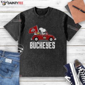 Alt Text: Premium Snoopy and Woodstock driving a car with Ohio State Buckeyes flag on a washed t-shirt design.