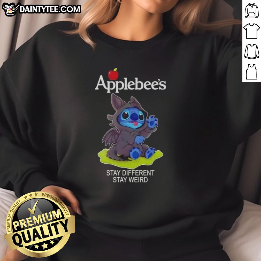 Alt Text: Cute Stitch cosplay wearing a Toothless-themed sweatshirt at Applebee's, promoting Stay Different, Stay Weird message.