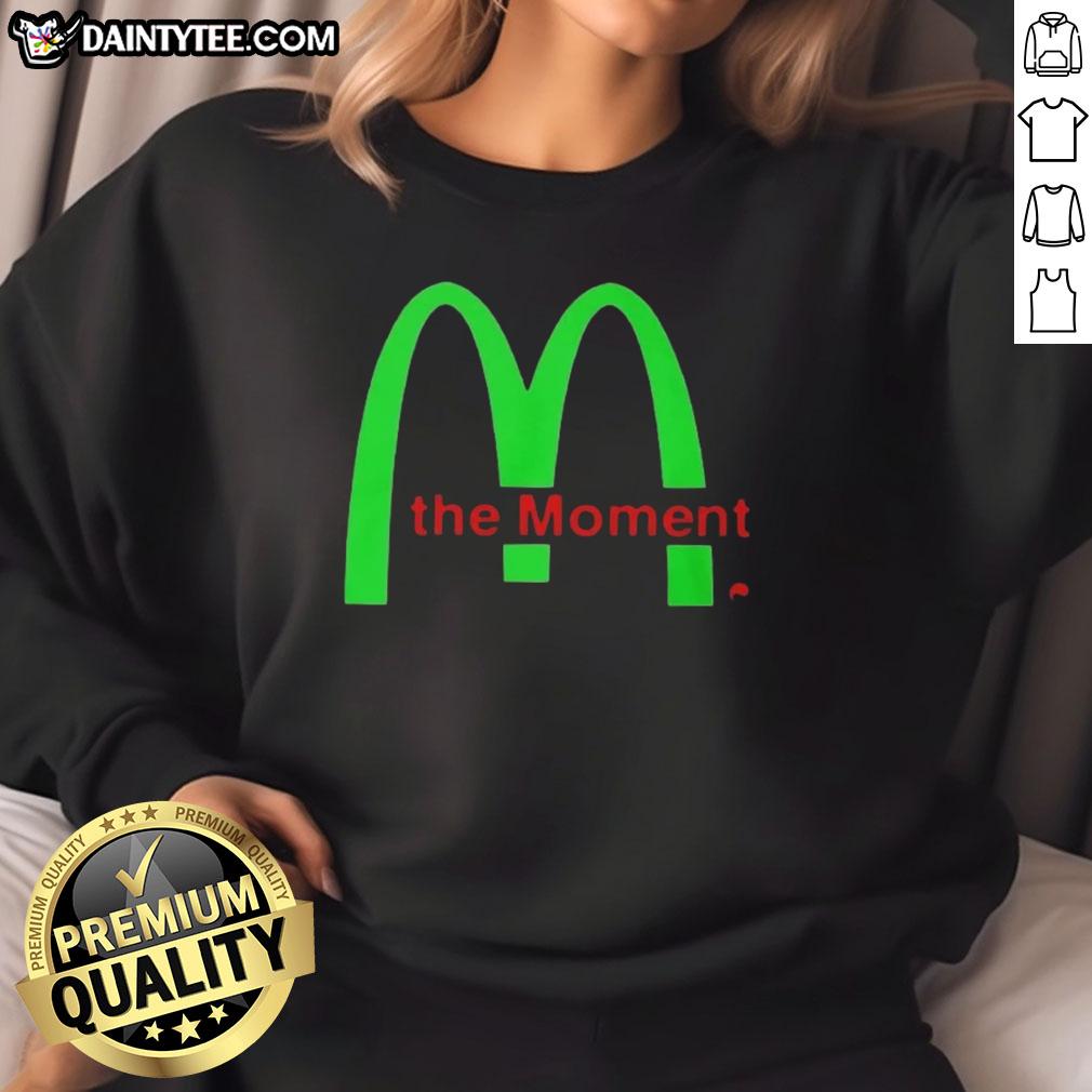 Alt Text: Charli XCX wearing a stylish 'Good Charli XCX The Moment Sweatshirt' in a vibrant urban setting.
