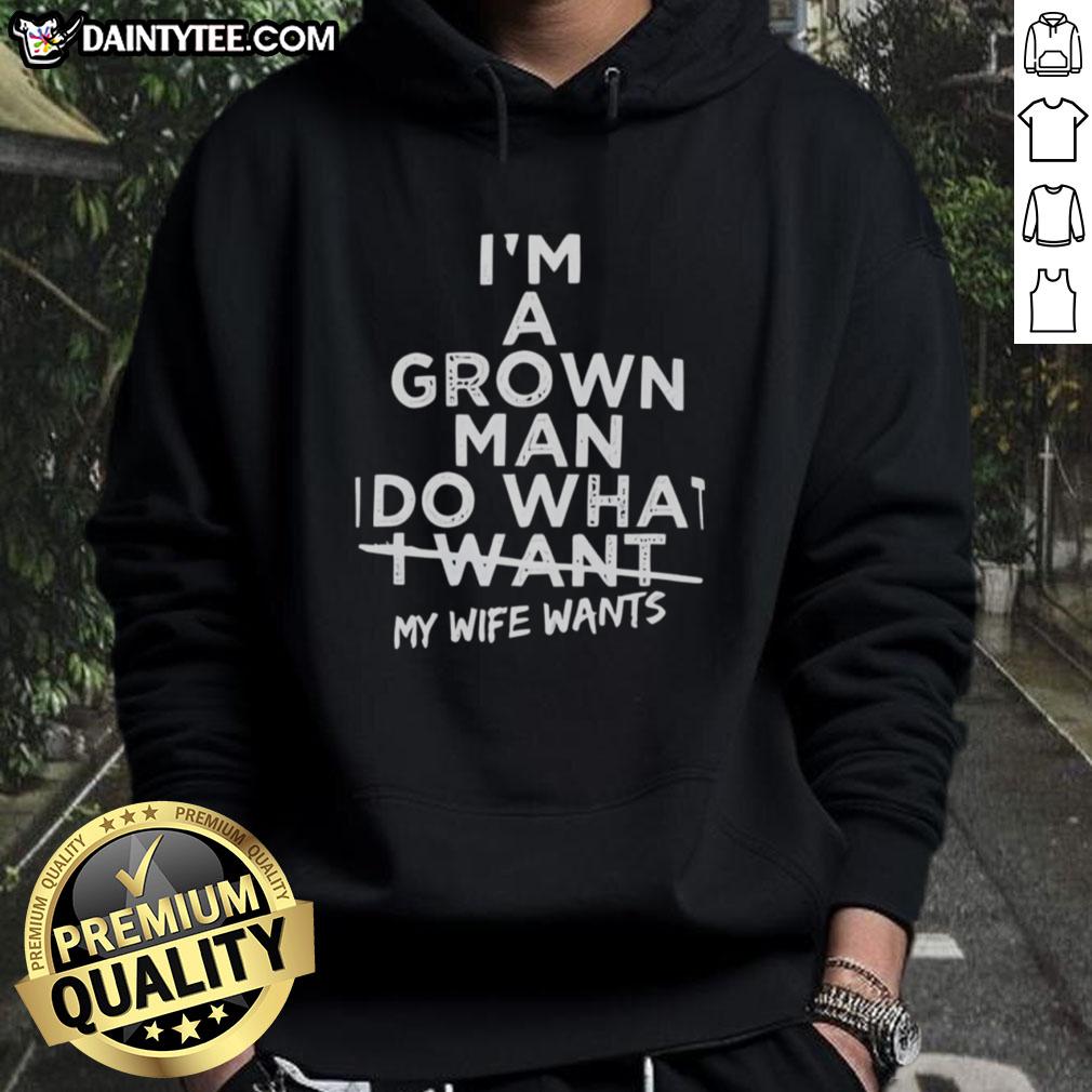 Man wearing 'Good I'm a Grown Man I Do What I Want My Wife Wants' hoodie, showcasing casual style and humor.
