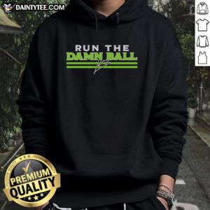Kenneth Walker III wearing a Seattle Seahawks 'Hot Run The Damn Ball' signature hoodie on the field.