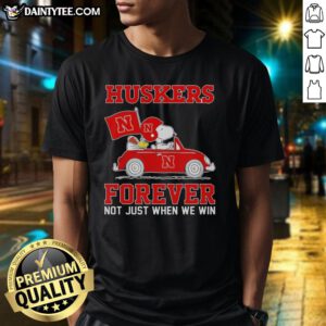 Hot Snoopy and Woodstock driving a car on a Nebraska Huskers T-shirt, perfect for fans of both Peanuts and college sports.