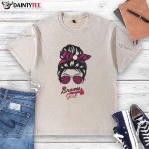 Alt Text: Cheerful girl with messy bun and glasses wearing a washed Atlanta Braves t-shirt, showcasing team spirit.