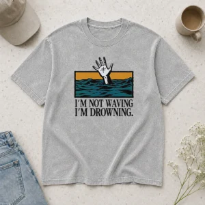Awesome I'M Not Waving I'M Drowning printed on a soft washed t shirt in light faded color