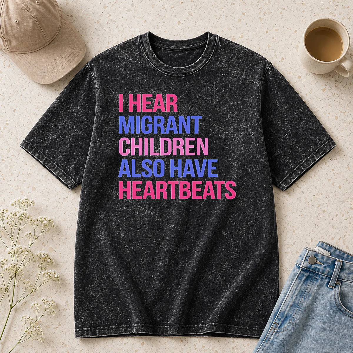 Good I Hear Migrant Children Also Have Heartbeats Bold Statement Text printed on a soft washed t shirt in light gray