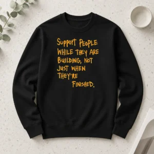 Hot Support People While They Are Building Not Just When They Are Finished Text printed on a black long sleeve shirt