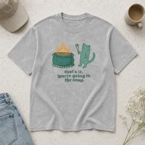 Top Happy Cat Holding Spoon Next To Cauldron You'Re Going In The Soup printed on a soft washed t shirt in light color